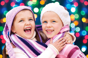 Cute girls hugging and laughing together on Christmas Eve