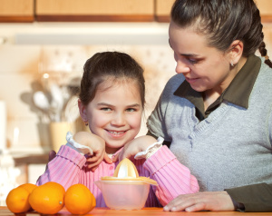 Woman and daughter making fresh fruit juice