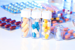 Colorful medical capsules in bottle, on white background.